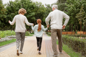 a photo of two grandparents holding hands with their grandchild