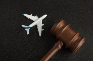 photo of a toy plane laying on a surface next to a law gavel representing child custody considerations for vacation and travel plans.